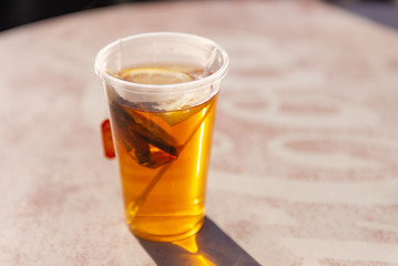 Tea. A glass of tea with lemon. Reflection of the sun in a glass of tea.