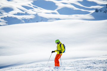 Fototapeta na wymiar Photo of sportive man skiing against background of snowy mountains