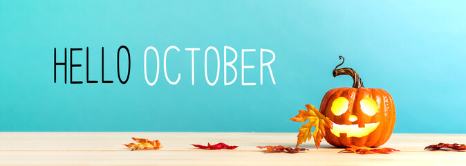 Hello October messag with pumpkin with leaves on a blue background - obrazy, fototapety, plakaty