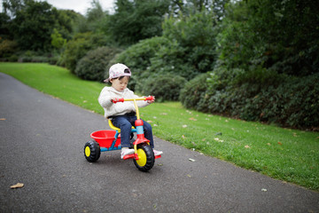 baby girl play bike in Summer forest park