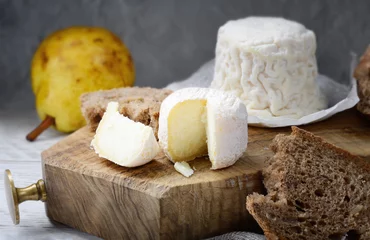 Gordijnen Crottin de Chavignol, French goat cheese on chopping board. © fabiomax