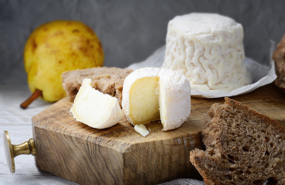 Crottin de Chavignol, French goat cheese on chopping board.