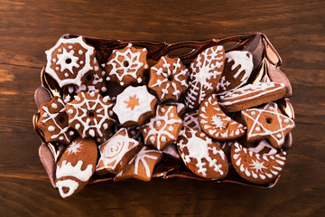 Pastry dough with icing, stacked in a glass plate on a wooden background.