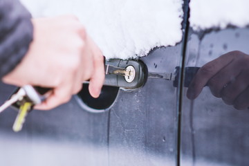 Man unlocking frozen car lock.