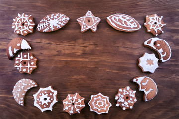 Cookies for Christmas meeting in the shape of an oval, a star and a month on a wooden background, space to copy.