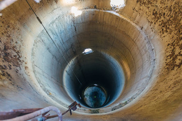 Old ruined concrete tube of abandoned dryer for grain. Vertical tubing shaft, view from above