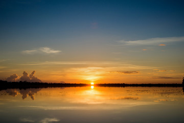 Sunset in the lake. beautiful sunset behind the clouds above the over lake landscape background. dramatic sky with cloud at sunset