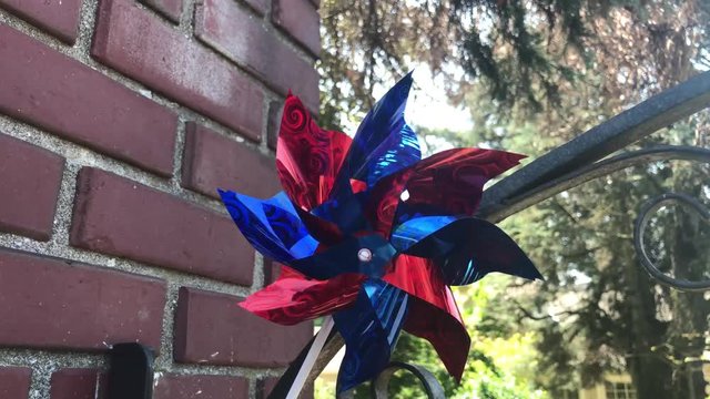 A simple blue and red plastic pinwheel spins in the breeze