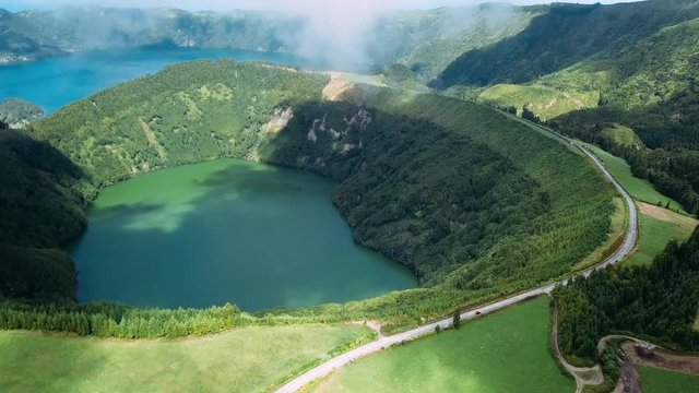 Flying over Lagoa Verde and Lagoa Azul, lakes in Sete Cidades volcanic craters on San Miguel island, Azores, Portugal. 