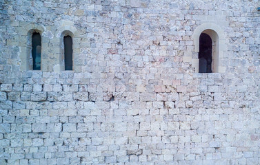 Fototapeta na wymiar Stone wall with Romanesque windows on the Templar crusader castle of Miravet in Tarragona, Spain.