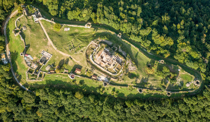Aerial panorama of ruined medieval Saris castle in Slovakia with round towers, donjon, walls, and blue sky background