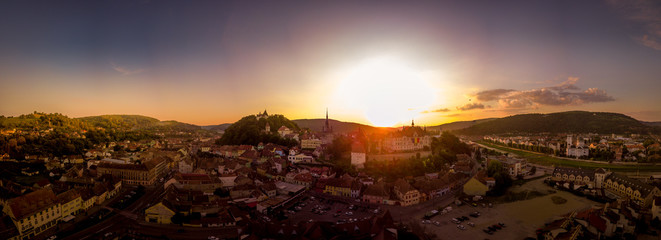 Sunset panorama of medieval Sighisoara with colorful, red, yellow, orange, purple sky