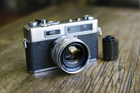 Front view of an old rangefinder film camera with a roll of film