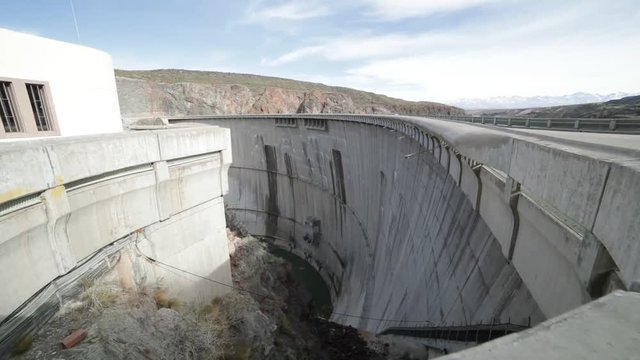 Detail of semi circular concrete support of Agua de Toro Dam. Hand held camera walking towards metal railing and leaning downwards looking the huge precipice. San Rafael, Argentina