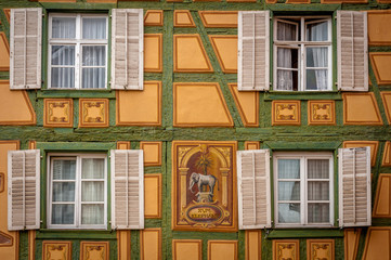 Old window on yellow and green wood panel in France