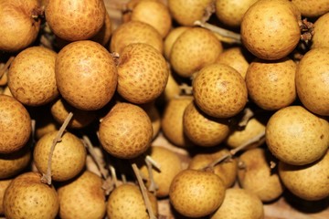 Longan fruits or Dimocarpus longan or Dragon eye fruit on the wooden wicker.