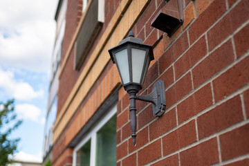 Fototapeta na wymiar Street lamp on the side of the red brick building in the new modern luxury neighborhood.