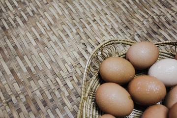 Fresh chicken eggs on wooden wicker.