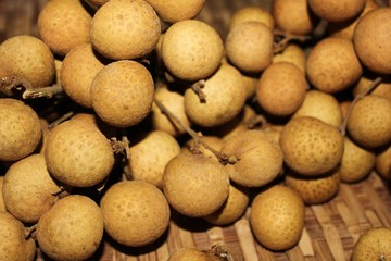 Longan fruits or Dimocarpus longan or Dragon eye fruit on the wooden wicker.