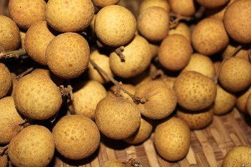 Longan fruits or Dimocarpus longan or Dragon eye fruit on the wooden wicker.