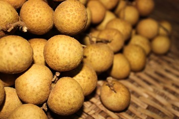 Longan fruits or Dimocarpus longan or Dragon eye fruit on the wooden wicker.