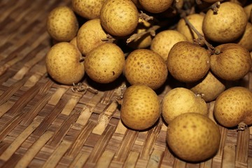 Longan fruits or Dimocarpus longan or Dragon eye fruit on the wooden wicker.