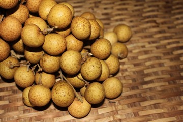Longan fruits or Dimocarpus longan or Dragon eye fruit on the wooden wicker.