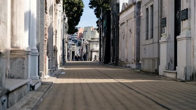 Street path in La Recoleta Cementery with tourists at daytime low angle shot