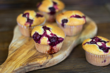 Muffins with cherry and chocolate on a wooden board. Closeup