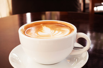 Hot coffee latte on a wooden table.