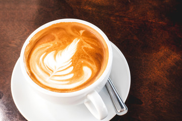 Hot coffee latte on a wooden table.