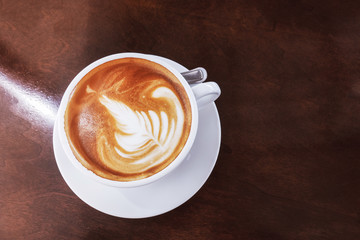Hot coffee latte on a wooden table.