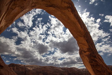 Corona Arch silhouetted against the sun. A free standing sandstone arch near Moab Utah.