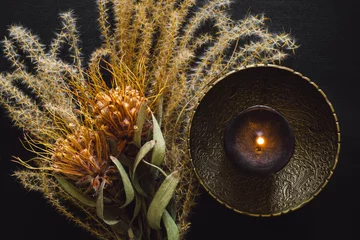 Messingschale mit schwarzer Kerze und getrocknetem Federgras und Blumen © Serena Tayyan