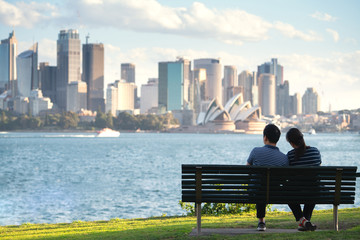 Asian couple sit and relax after running in a park in sydney - obrazy, fototapety, plakaty