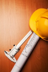 Hardhat on top of blue prints and calipers