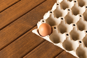 Egg in a cardboard box on a wooden table. Close up. Macro