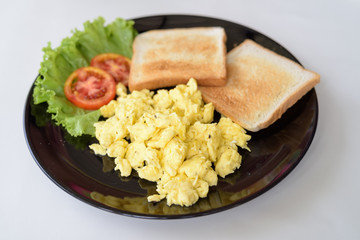 Delicious Scrambled Eggs With Toast On White Table