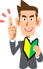 初心者マークを手に持ち説明するスーツを着た男性
