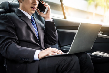 Attractive handsome young businessman using mobile smart phone in car