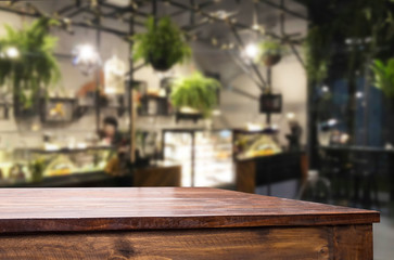 Selected focus empty brown wooden table and Coffee shop or restaurent blur background with bokeh image. for your photomontage or product display