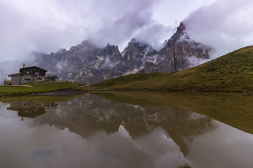 Dramatic sunset with rain clouds and rocky peaks in the Dolomite Alps, Italy, in summer