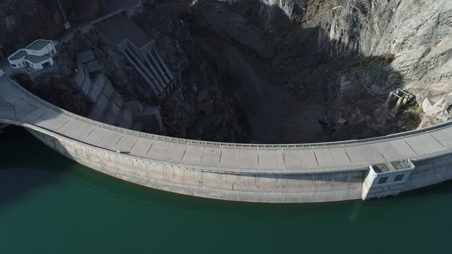 Aerial drone scene top view of Agua de Toro Dam at San Rafael, Mendoza, Cuyo Argentina. Camera moving forward and panning down. First light of the day. Reflection in lake.