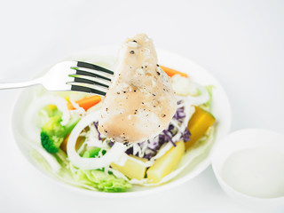 Pepper chicken with salad on white background