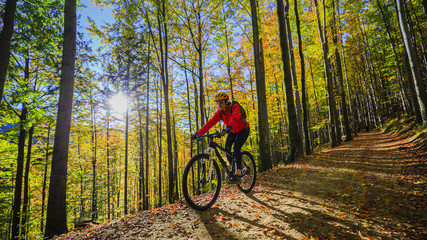 Cycling, mountain biking woman on cycle trail in autumn forest. Mountain biking in autumn landscape...