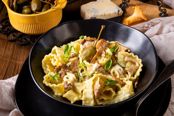 Reginette noodles in cream sauce with fresh chanterelles and capers