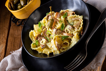 Reginette noodles in cream sauce with fresh chanterelles and capers