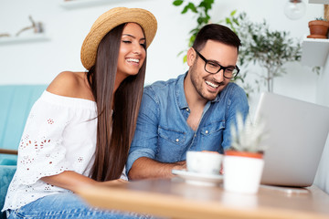 Smiling couple looking at laptop screen indoors