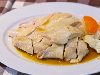 Chinese steamed chicken with sauce on a white plate on red checked Pattern tablecloth