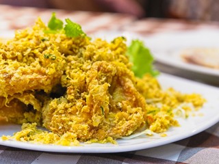 Crispy fried prawns on a white plate decorate with green lettuce on red checked Pattern tablecloth. Closeup